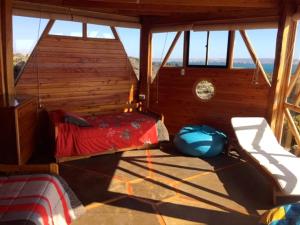 een slaapkamer met een bed in een kamer met ramen bij Loco´s Home in Chañaral de Aceituna