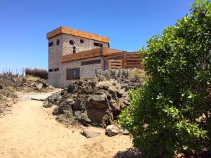 a house sitting on top of a hill next to a dirt road at Loco´s Home in Chañaral de Aceituna