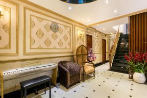 een kamer met een piano, een stoel en een trap bij Indochine Ben Thanh Hotel & Apartments in Ho Chi Minh-stad