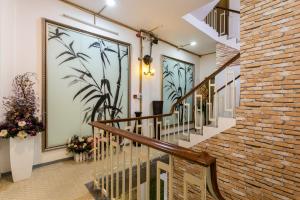 a staircase in a building with a brick wall at Indochine Ben Thanh Hotel & Apartments in Ho Chi Minh City