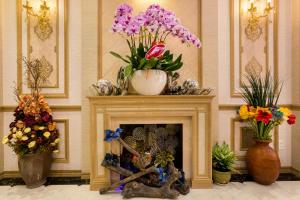 a fireplace with a vase of flowers on top of it at Indochine Ben Thanh Hotel & Apartments in Ho Chi Minh City