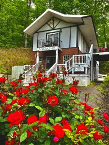 una casa con flores rojas delante de ella en Grafton Lodge, en Lake Lure