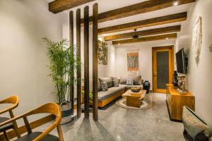 a living room with a couch and a tv at Ubud Season Villas in Ubud