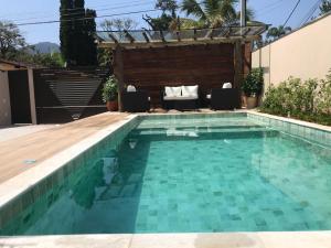 a swimming pool in the backyard of a house at Flats de Sumatra in Boicucanga