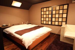 - une chambre avec un grand lit et une fenêtre dans l'établissement Hida Takayama Hotel Viera Resort (Adult Only), à Takayama