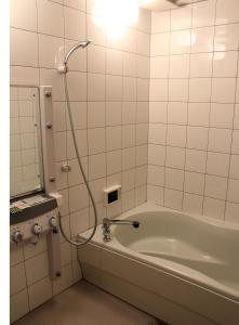 La salle de bains est pourvue d'une baignoire et d'une douche. dans l'établissement Hida Takayama Hotel Viera Resort (Adult Only), à Takayama