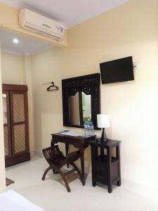 a desk with a mirror and a chair in a room at Diana Hotel Jogja in Yogyakarta