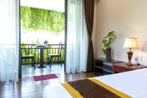 a hotel room with a bed and a balcony at SHALA BOUTIQUE HOIAN in An Bang +60 photos