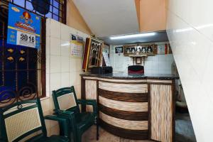 a bar in a restaurant with two green chairs at Jaya Krishna Mansions in Vellore