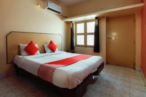 a bedroom with a large bed with red pillows at Jaya Krishna Mansions in Vellore