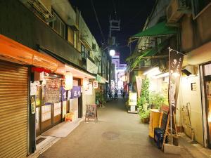 a city street at night with people walking down it at Hostel J Culture168 in Toyonaka