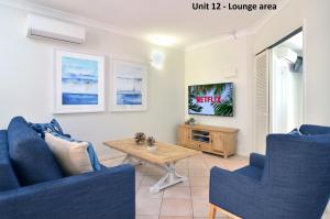 a living room filled with furniture and a tv at The Newport on Macrossan in Port Douglas