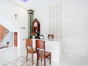 a dining room with a table and chairs and a clock at OYO 4003 Ceria Guesthouse Seminyak in Seminyak