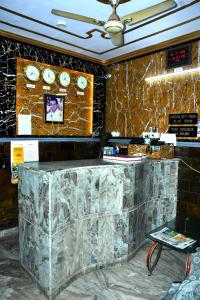 a lobby with a marble counter with clocks on the wall at Mother Palace in New Delhi