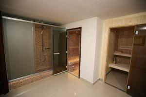 a bathroom with a walk in shower and a glass shower backdoor at Tokalis Boutique Hotel & Spa in Nea Anchialos