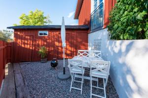 un patio con mesa, 2 sillas y sombrilla en Stockholm Archipelago apartment, en Vaxholm