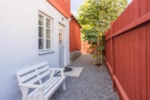 a white bench sitting next to a building at Stockholm Archipelago apartment in Vaxholm