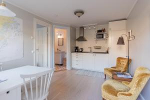 cocina y sala de estar con 2 sillas y mesa en Stockholm Archipelago apartment en Vaxholm