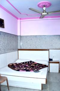 um quarto com uma cama com um tecto rosa em Mother Palace em Nova Deli