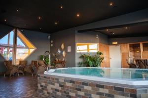 a large hot tub in a room with chairs and tables at Hotell Wilhelmina in Vilhelmina