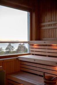 a sauna with two windows and a chair in it at Hotell Wilhelmina in Vilhelmina