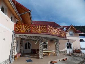 a house with a balcony on top of it at Pensiunea Paradiso in Poiana Teiului