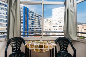 un tavolo e due sedie davanti a una finestra di Apartamento Pino Torremolinos a Torremolinos
