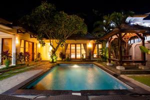 a swimming pool in front of a house at night at Dura Villas Canggu Bali in Kerobokan