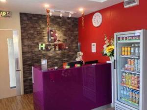 a store with a purple counter and a red wall at B+ Hotel in Sungai Petani