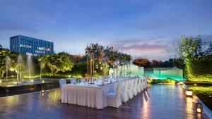 a long table with white chairs in front of a fountain at C&D Hotel,Xiamen Xiang'an-Late Check Out & Free Welcome Snacks in Xiamen