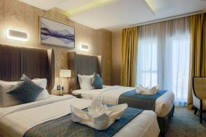 a hotel room with two beds and a window at The Proud Hotel Al Khobar in Al Khobar