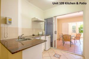 a kitchen with a sink and a refrigerator at The Newport on Macrossan in Port Douglas