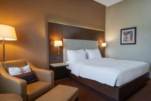 um quarto de hotel com uma cama grande e uma cadeira em Radisson Blu Hotel, Addis Ababa em Addis Ababa