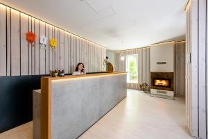 a woman sitting at a bar in a room with a fireplace at Hotel Veverica in Trenčín