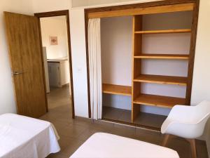 a room with a closet and a table and a chair at Apartamentos Verde Mar in Es Pujols