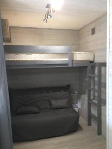 Ce lit superposé se trouve dans un dortoir doté d'un canapé. dans l'établissement Les Fougères, à Gréolières-les-Neiges