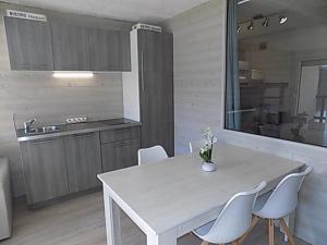 - une cuisine avec une table blanche et des chaises blanches dans l'établissement Les Fougères, à Gréolières-les-Neiges