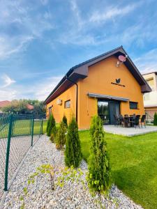 a yellow building with a fence in a yard at Apartmánové domy Kaja, Niko, Simi in Veľký Meder