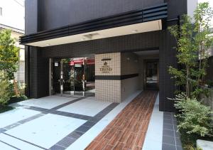 a black brick building with a glass door at Hotel Trend Omiya in Saitama