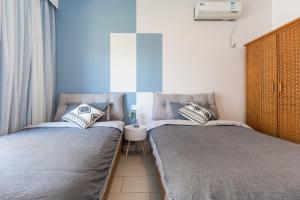 2 camas individuales en una habitación con ventana en Sanya Sun Seaview Apartment, en Sanya