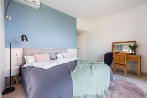 um quarto com uma cama com uma parede azul em Sanya Sun Seaview Apartment em Sanya