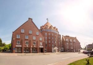 ein großes Backsteingebäude mit einem Kreuz darüber in der Unterkunft Golden Tulip Luebecker Hof in Lübeck