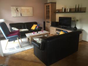 sala de estar con sofá negro y mesa en Ferienwohnung Unter dem Schild en Oberfell