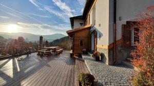 a wooden deck with a table and a building at Magic House Under Arber in Bayerisch Eisenstein