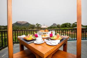 a table with plates of food on a balcony at Sigiriya King's Resort in Sigiriya