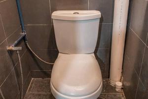 ein weißes WC im gefliesten Bad in der Unterkunft SK Budget Hotel in Jelutong