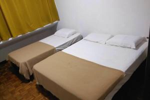 2 Betten nebeneinander in einem Zimmer in der Unterkunft SK Budget Hotel in Jelutong