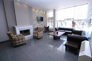a living room with furniture and a fireplace at Tokalis Boutique Hotel & Spa in Nea Anchialos