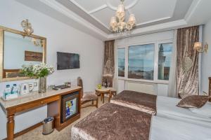 Habitación de hotel con cama, escritorio y TV. en Antis Hotel-Special Category, en Estambul