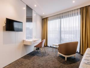 a hotel room with a table and chairs and a television at Özkum Tesisleri in Sapanca